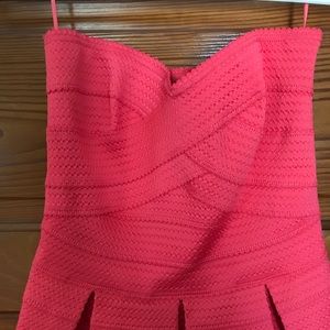 Strapless coral colored bandage style dress.